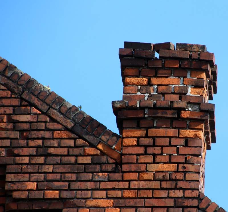 Damaged chimney on an Smiths Creek home showing cracks and missing mortar